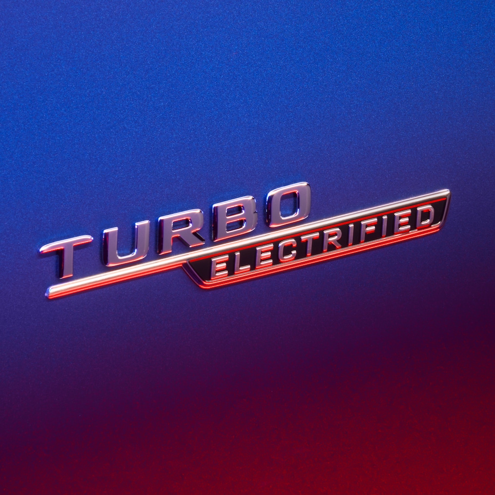 TURBO E PERFORMANCE felirat az első sárvédőn, piros fénnyel megvilágítva.