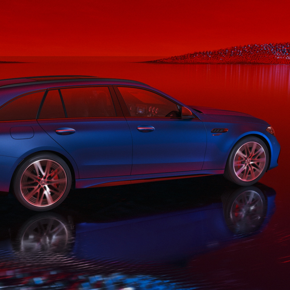 A Mercedes-AMG C 63 S E PERFORMANCE T-modell MANUFAKTUR spectral-kék magno színben, oldalnézetben egy piros háttér előtt.