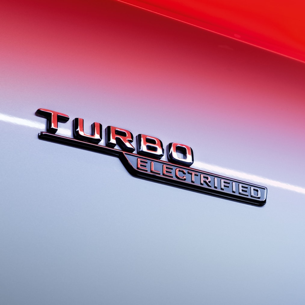 Közeli kép a TURBO ELECTRIFIED felirat a hűtőrácson.
