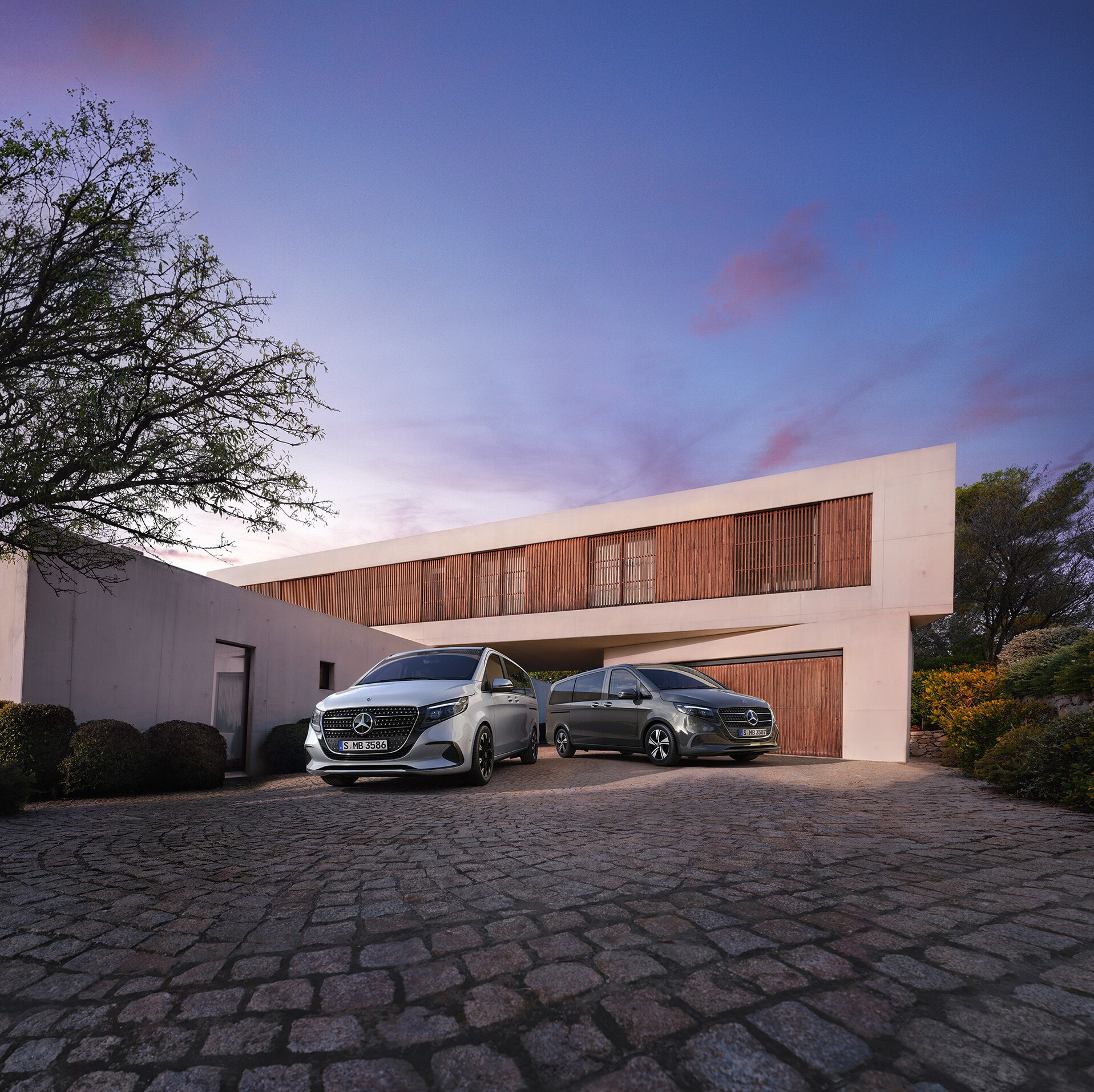 A Mercedes‑Benz V-osztály alkonyatkor egy modern luxusház előtt.