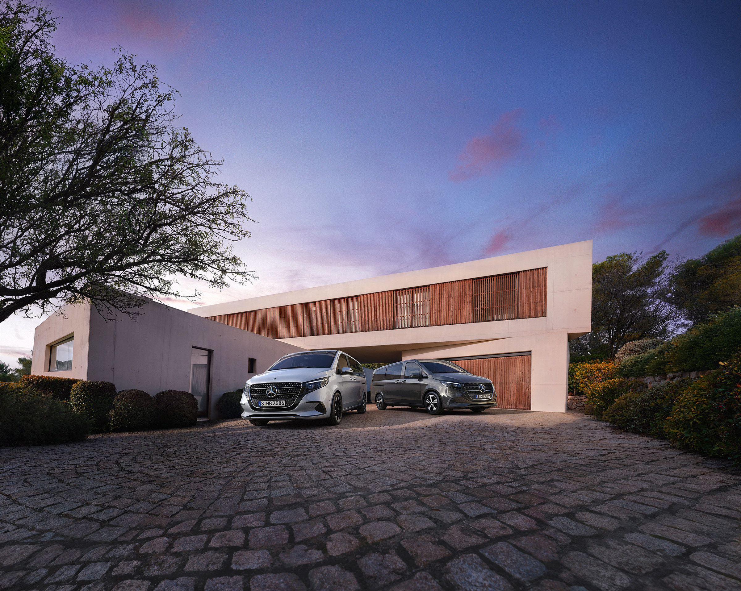 V-osztály | Buszlimuzin és lakóautó modellek | Mercedes-Benz gépjárművek A Mercedes‑Benz V-osztály alkonyatkor egy modern luxusház előtt.