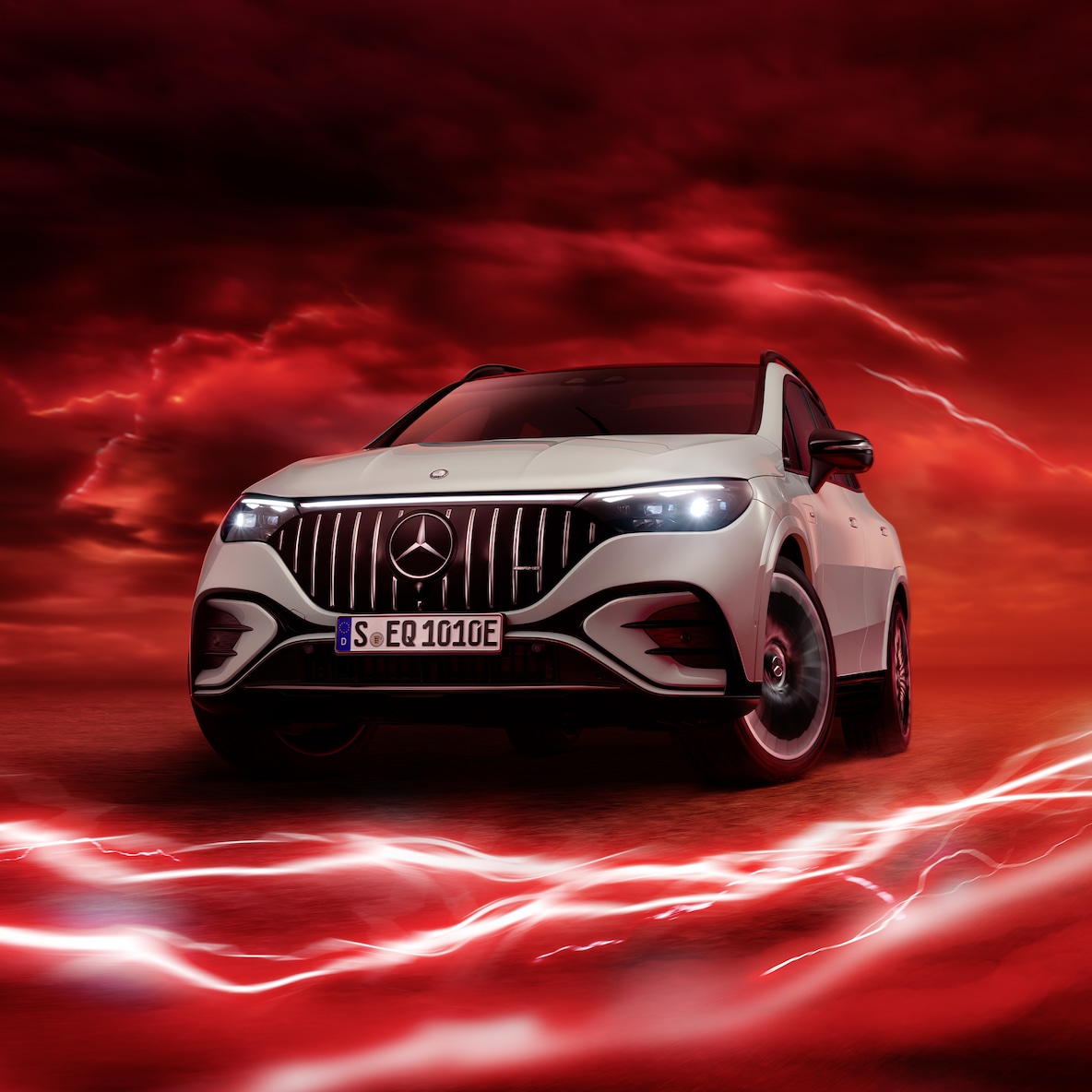 A Mercedes-AMG EQE 53 4MATIC+ elölnézetben egy piros háttér előtt.