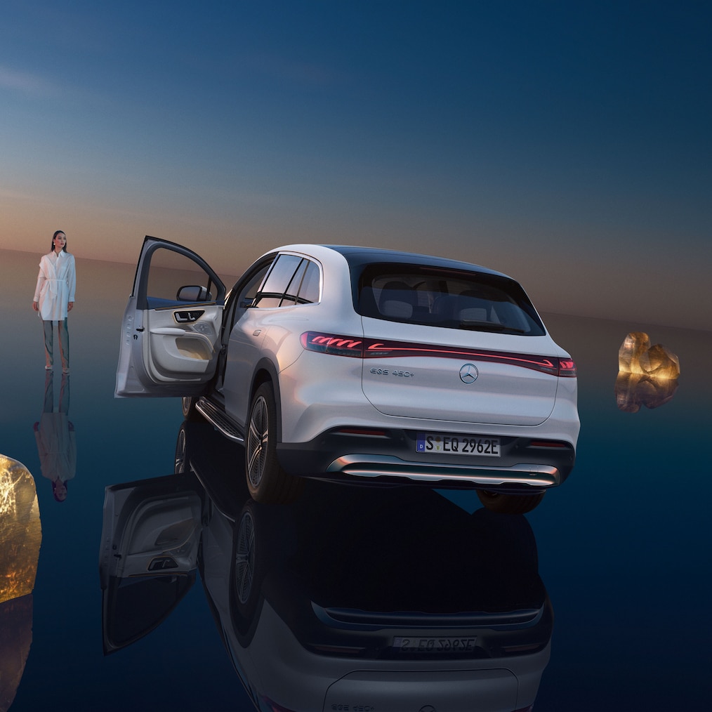 Az EQS SUV hátulsó nézete nyitott vezető oldali ajtóval.