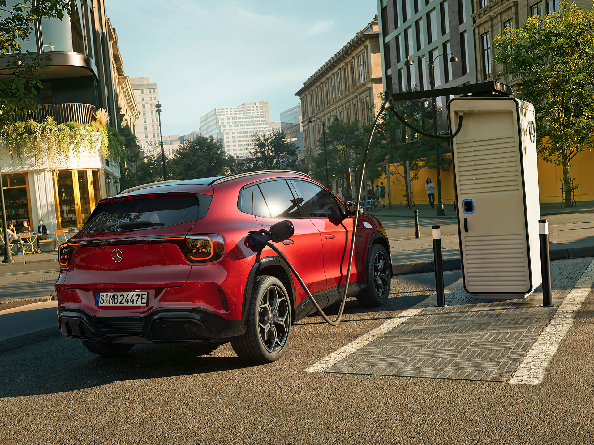 Hatótávolság és töltés | Az új, elektromos GLA | Mercedes-Benz Az új, elektromos Mercedes-Benz GLA egy töltőállomás mellett áll, miközben töltődik.