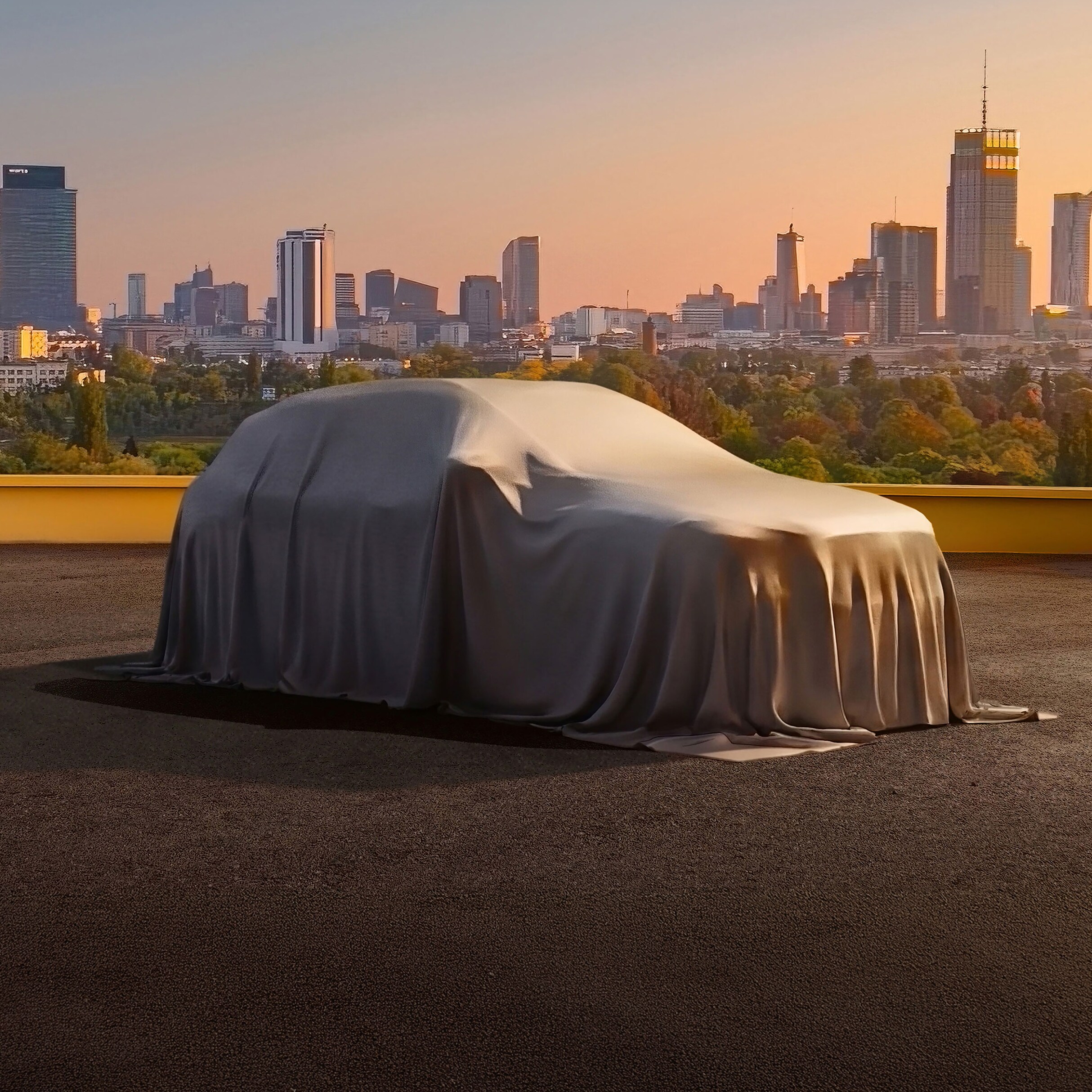 Az új Mercedes-Benz GLA lepel alatt, háromnegyed oldalnézetben látható egy parkolóban, városi háttér előtt.