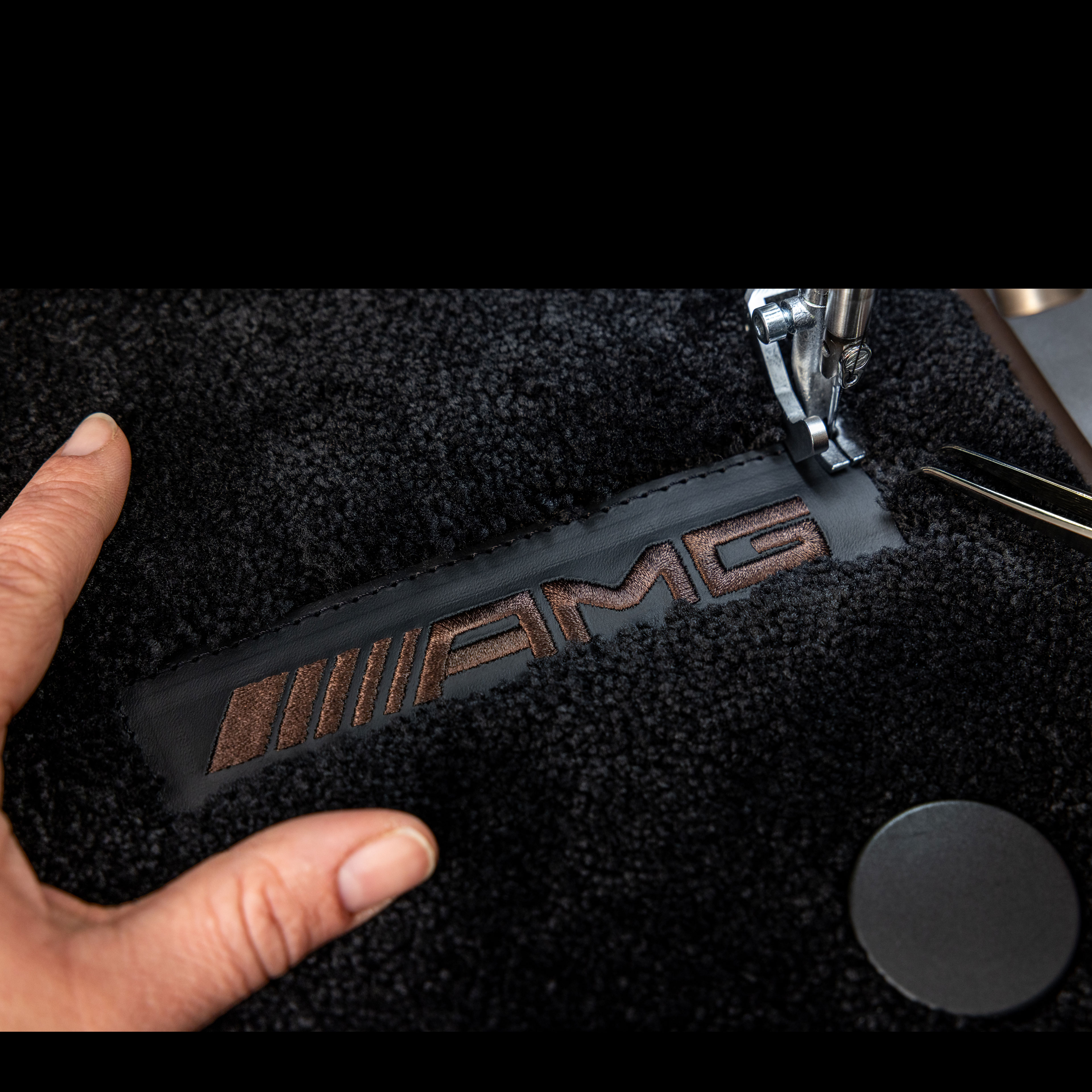 MANUFAKTUR | Mercedes-AMG MANUFAKTUR felirat egy Mercedes-AMG sötét felületén.