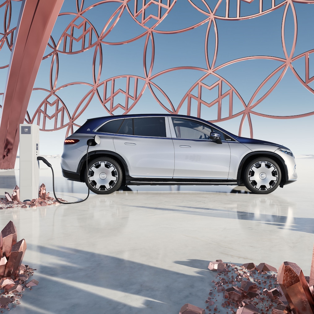 A Mercedes-Maybach EQS SUV oldalnézete a töltőállomáson a Maybach márkajelzéssel a háttérben.