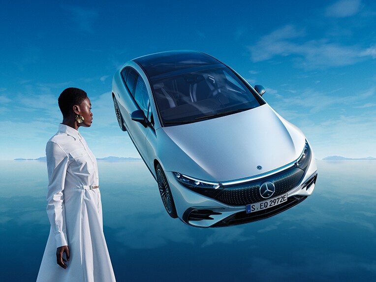 A Mercedes-Benz tisztán elektromos hajtású EQS modellje a saját kék EQ világában, tükröző padlófelülettel.