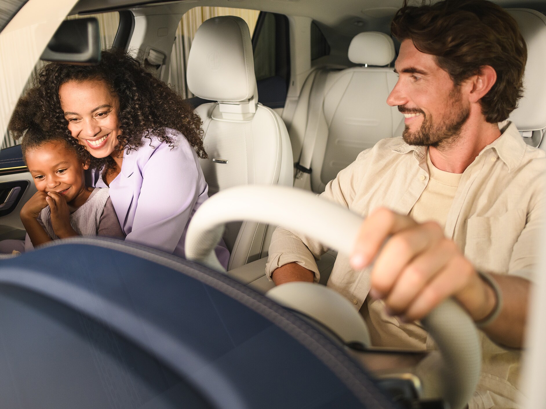 Két ember és egy gyermek a Mercedes-Benz jármű felé sétál.