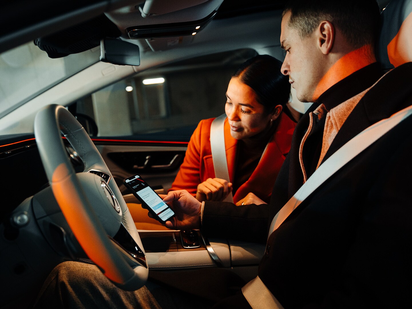 Egy Mercedes-Benz járműben ülő pár okostelefonon keresztül kárbejelentést intéz.