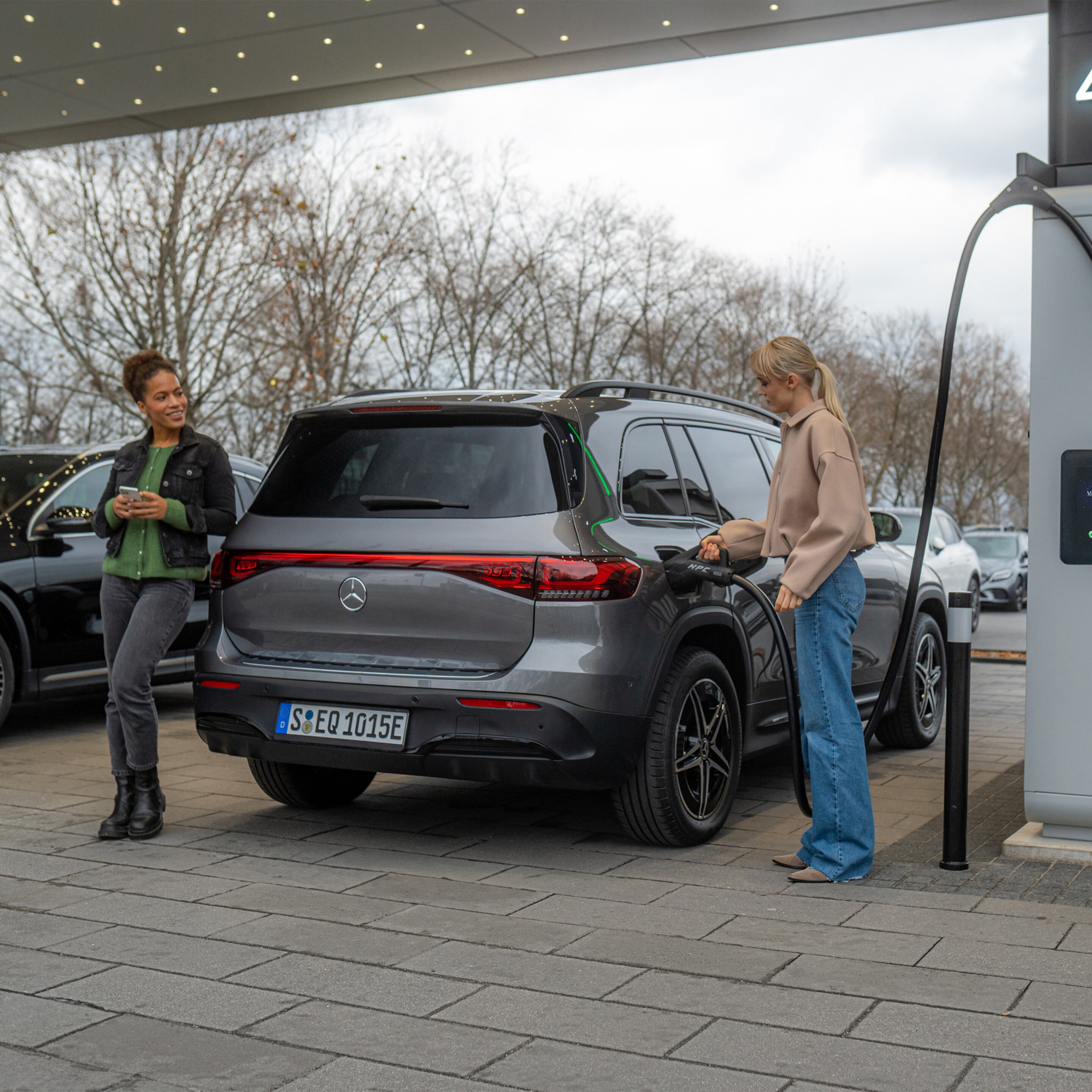 Két Mercedes-Benz elektromos gépkocsi egy töltőállomáson.