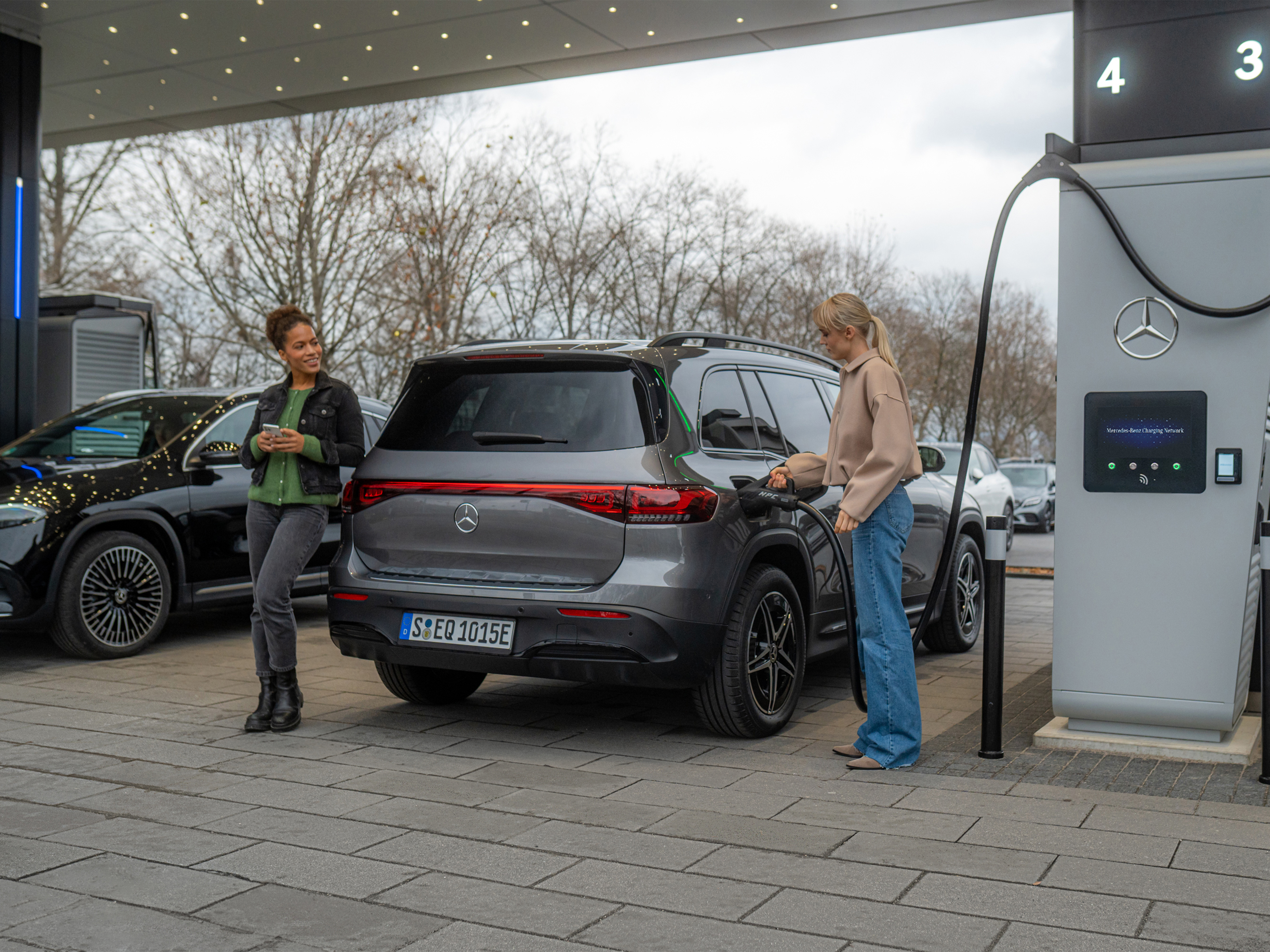 Mercedes-Benz töltőhálózat | Töltés útközben | Mercedes-Benz Két Mercedes-Benz elektromos gépkocsi egy töltőállomáson.