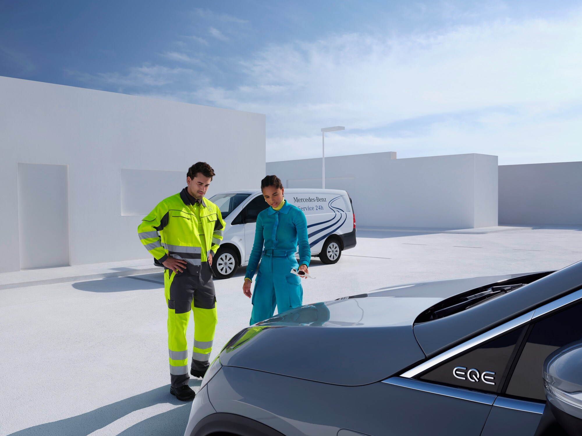 A Mercedes-Benz Service24 ügyfélszolgálat munkatársa egy Mercedes-Benz modell előtt egy ügyféllel konzultál.