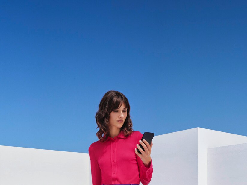 Egy nő telefonál Mercedes-Benz gépkocsija előtt