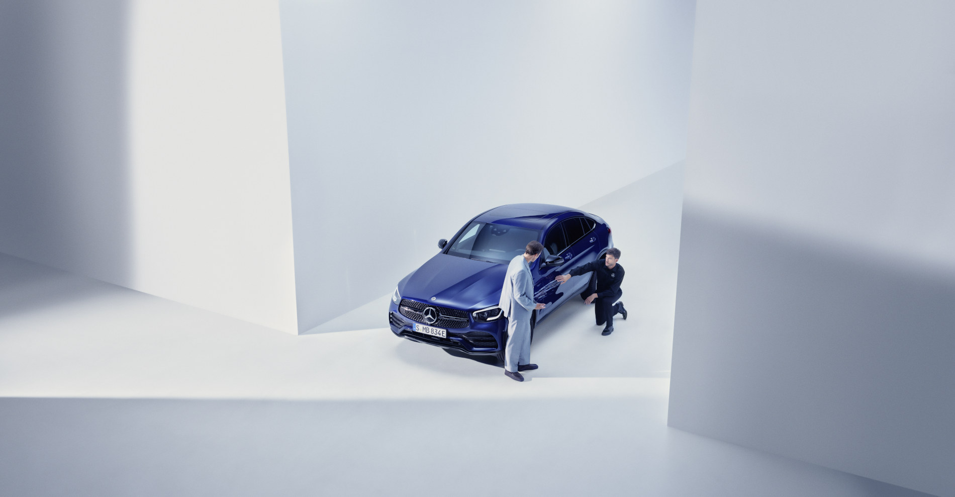 Baleseti és meghibásodási segítségnyújtás | Mercedes-Benz Egy nő áll a Mercedes-Benz előtt, telefonjával a kezében, és éppen telefonál