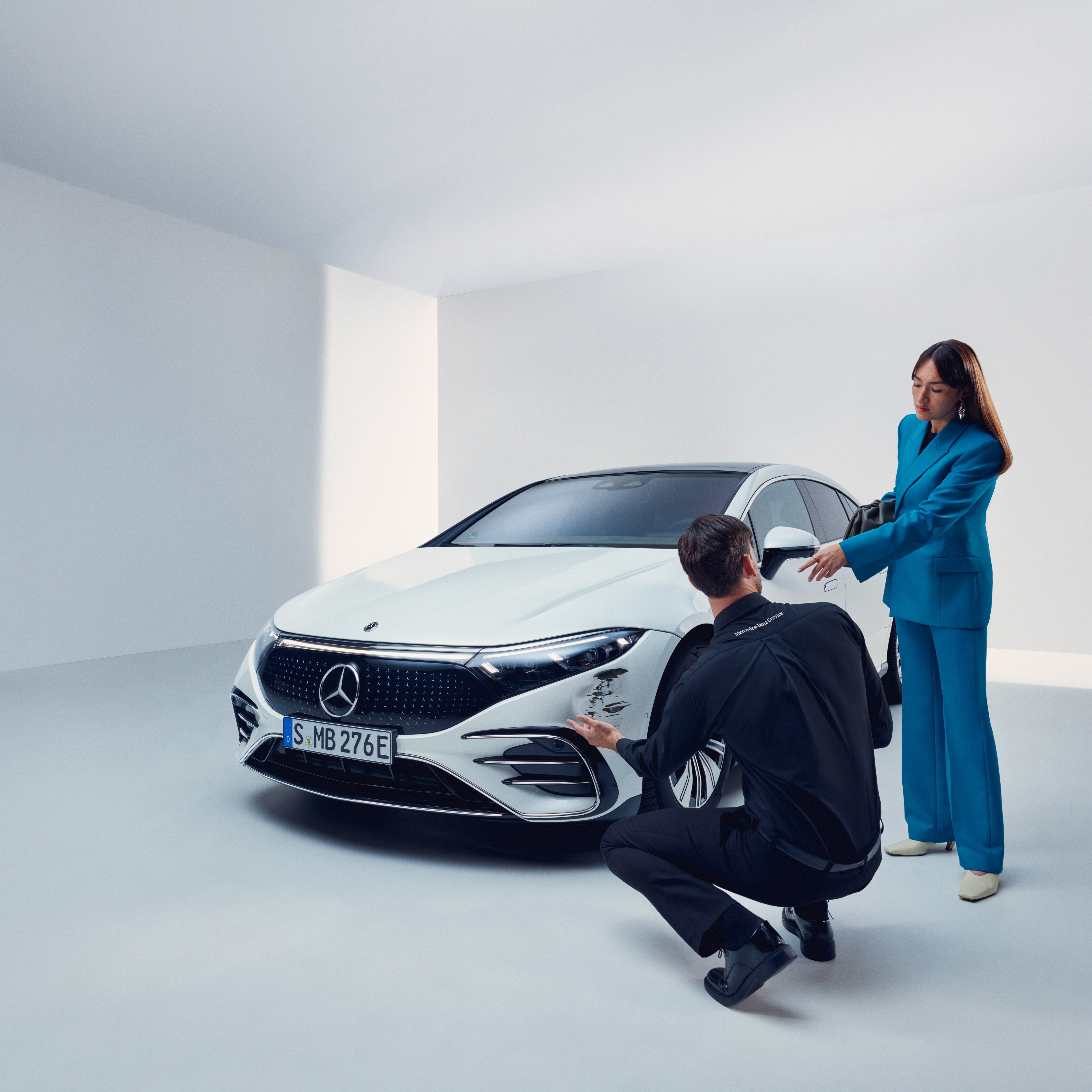 Egy Mercedesben ülő pár együtt néz egy okostelefont.