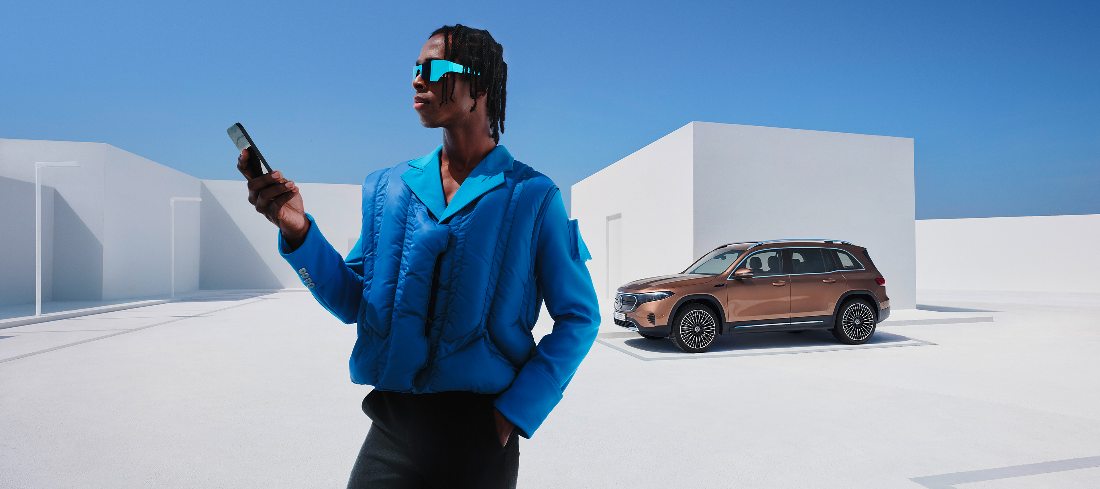 Mercedes-Benz alkalmazás | Mercedes-Benz Egy férfi a Digitális extrafelszereltségeken keresztül okostelefonjával kapcsolódik Mercedes-Benz gépkocsijához.