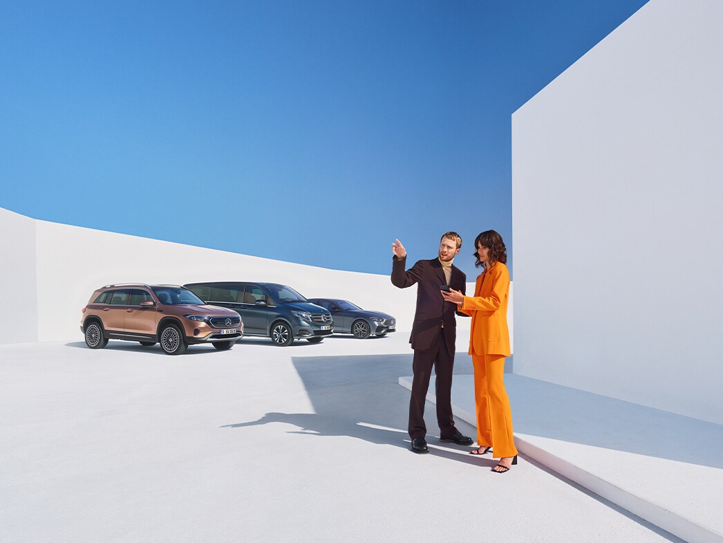 Egy férfi és egy nő több Mercedes-Benz gépkocsi előtt.