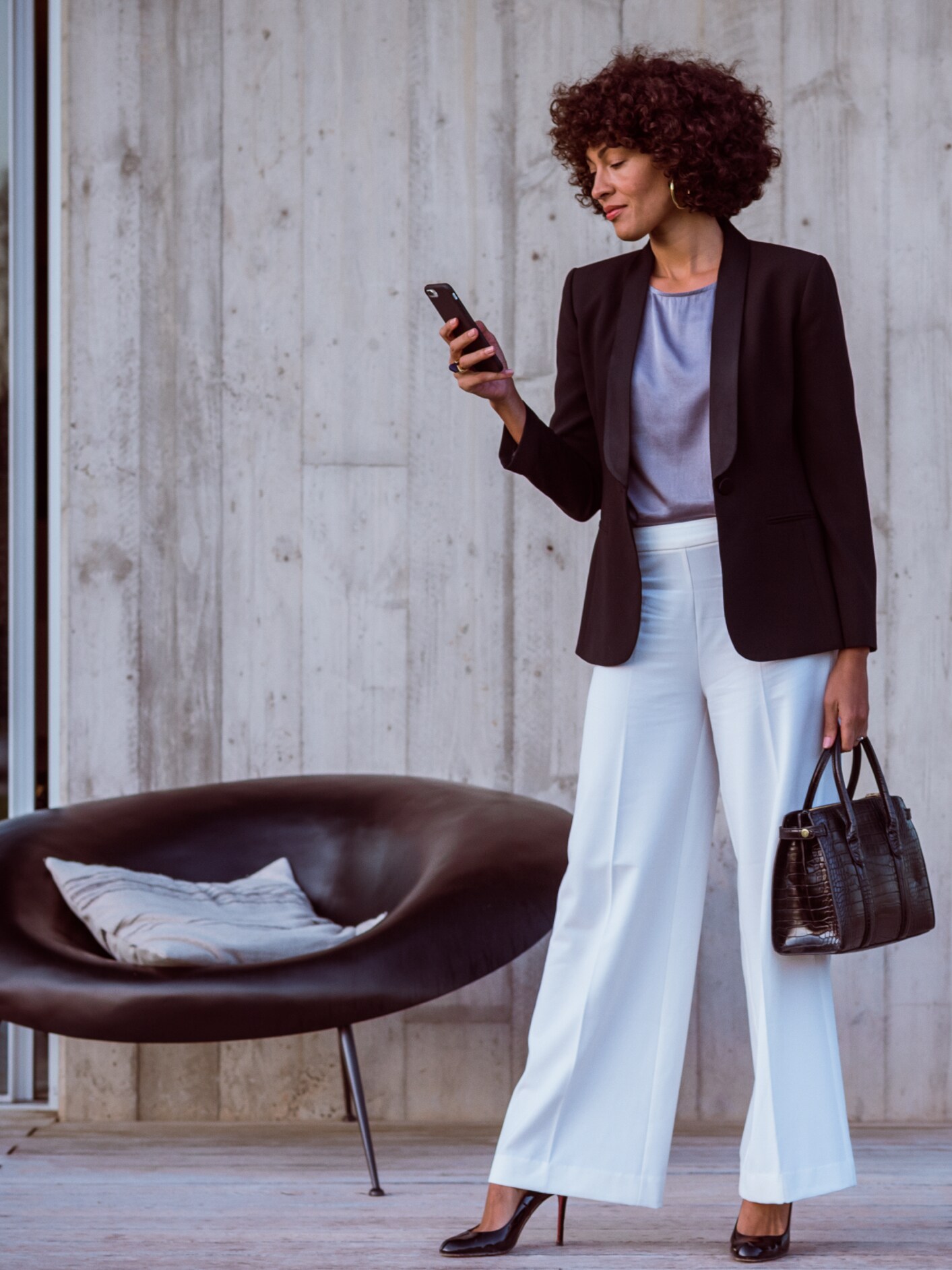 Egy nő okostelefonon, a Mercedes-Benz alkalmazáson és a Mercedes me ID-n keresztül csatlakozik Mercedes-Benz modelljéhez.