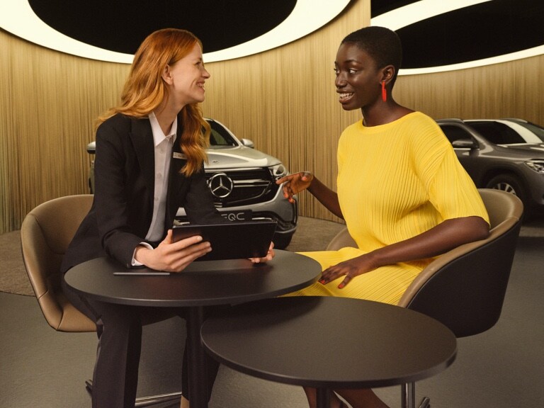 Két hölgy tablet segítségével ismerkedik a Mercedes digitális szolgáltatásaival