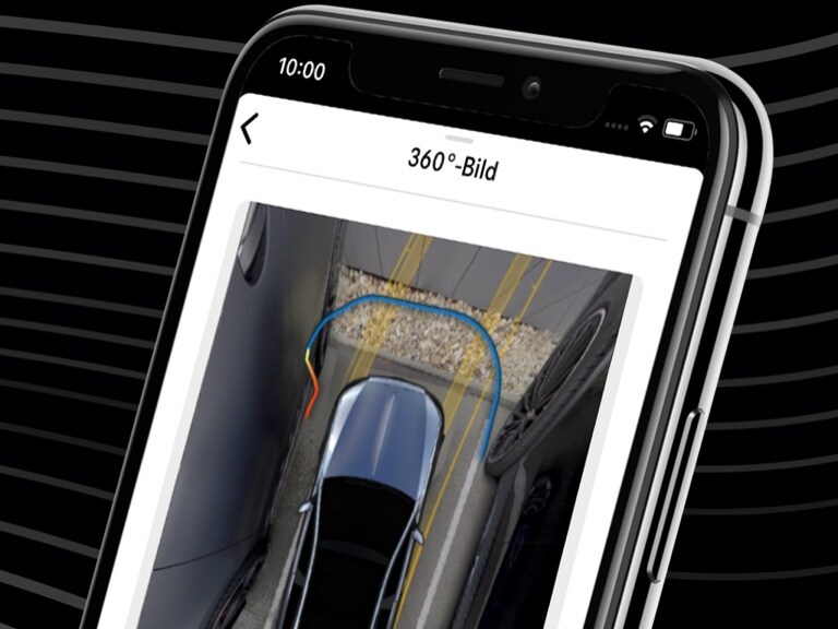 Egy Mercedes-Benz gépkocsi a Mercedes-Benz Távirányítható parkolásasszisztens alkalmazással és az okostelefon 360°-os nézetével kényelmesen bekormányozható egy szűk parkolóhelyre.