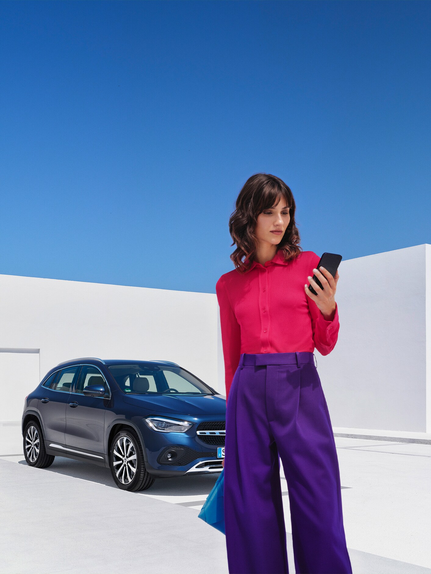 Mercedes-Benz alkalmazással csatlakozik járművéhez egy hölgy okostelefonról