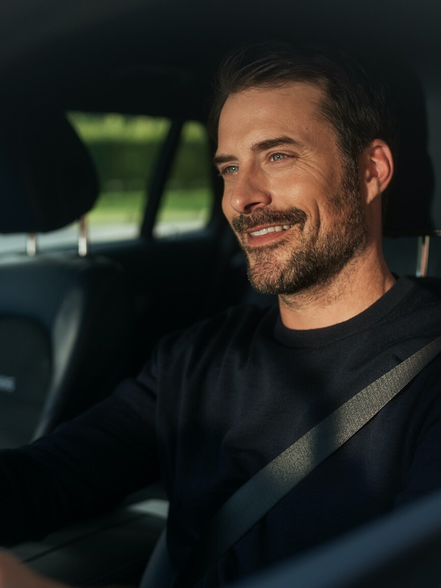 A képen látható férfi a Szórakoztató rendszer csomagnak köszönhetően zavartalanul élvezheti az internetrádiózást Mercedes-Benz modelljében.