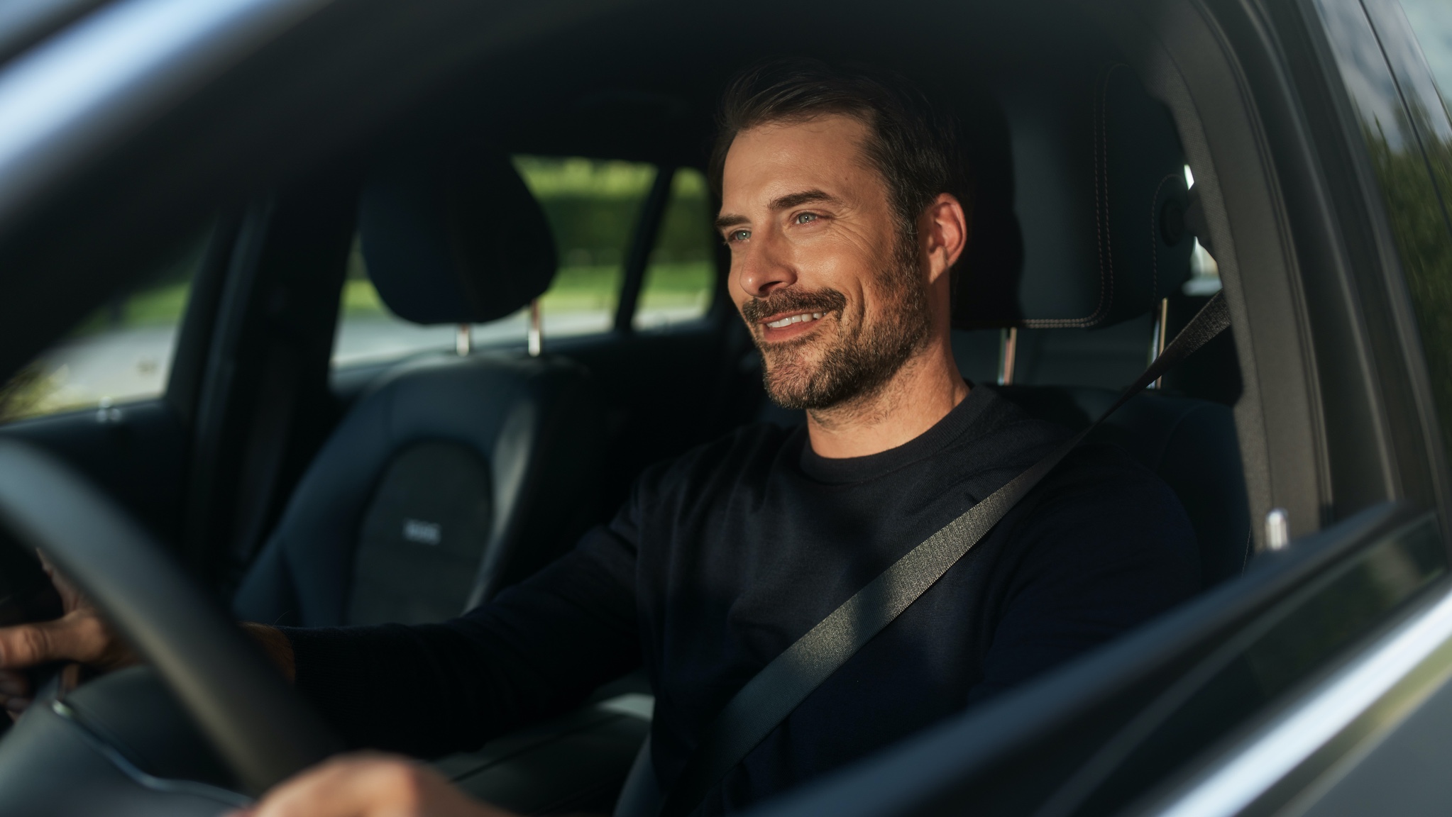 Rádióállomás-követés| Szórakoztatás | Mercedes-Benz A képen látható férfi a Szórakoztató rendszer csomagnak köszönhetően zavartalanul élvezheti az internetrádiózást Mercedes-Benz modelljében.