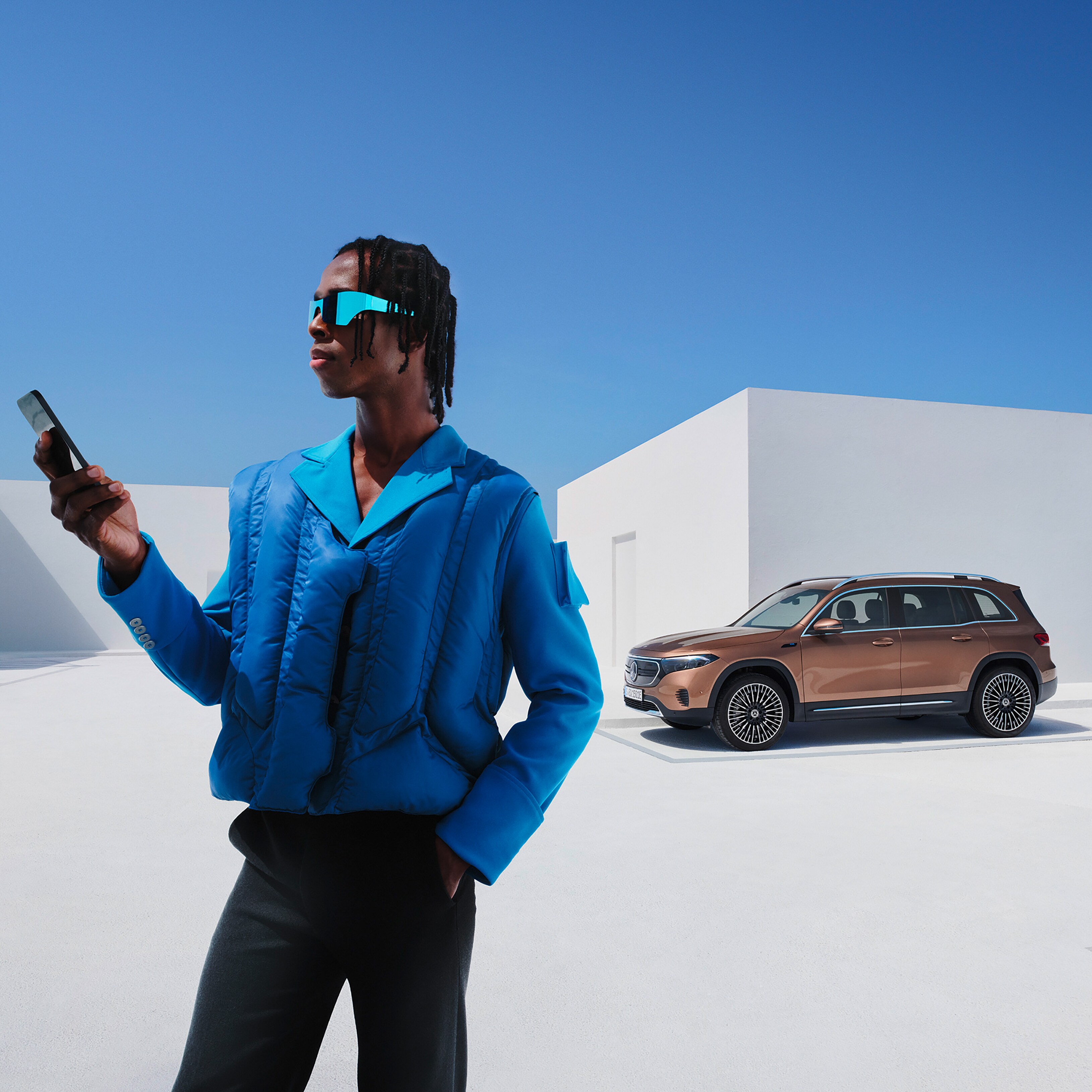 Egy férfi egy Mercedes-Benz EQB előtt.