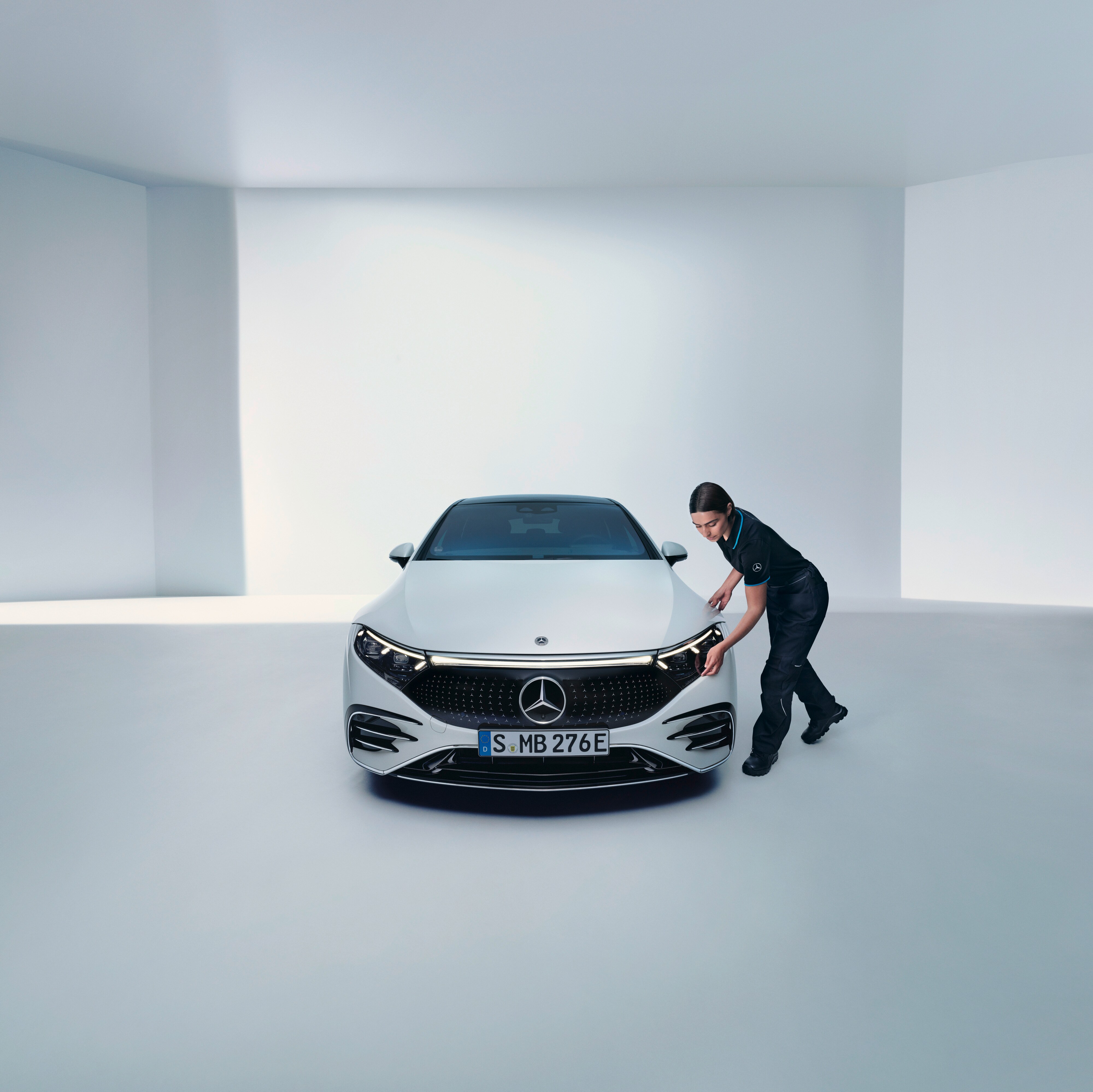 Egy Mercedes-Benz szerelő egy fényszórót ellenőriz.