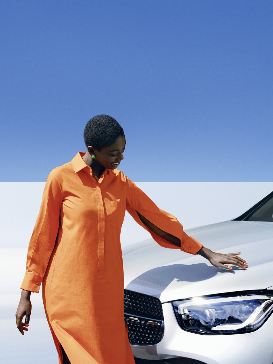 Egy Mercedes-Benz gépkocsi mellett álló személy.