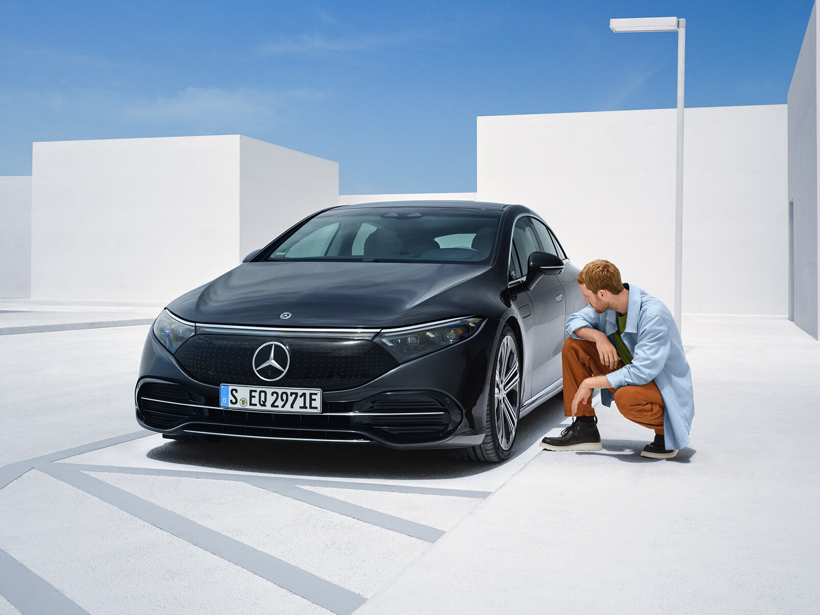 Egy férfi sérülések szempontjából megvizsgálja Mercedes-Benzét.