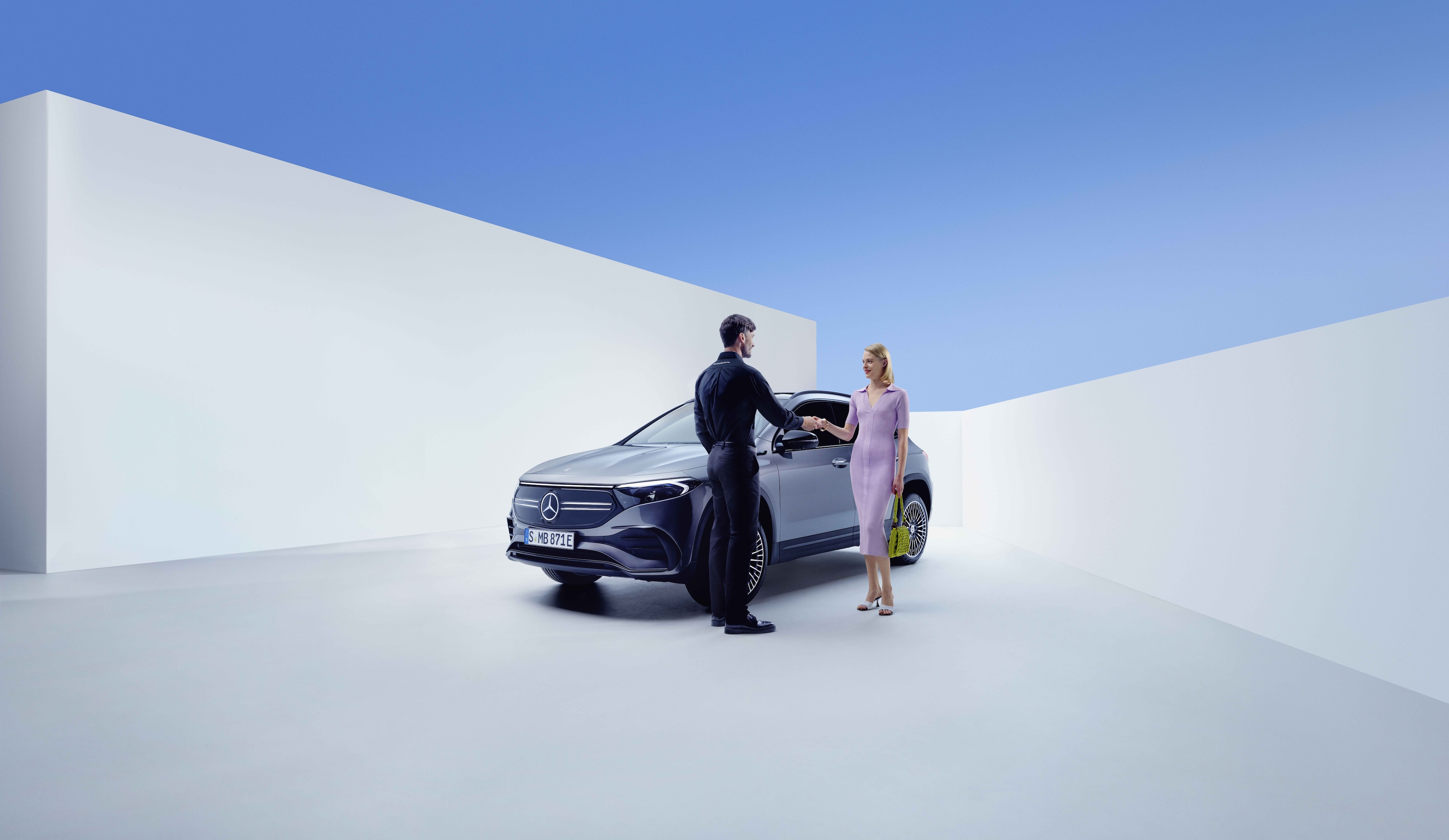 Szerviz és javítás | Mercedes-Benz Egy Mercedes-Benz alkalmazott és egy nő kezet ráznak egy Mercedes-Benz előtt