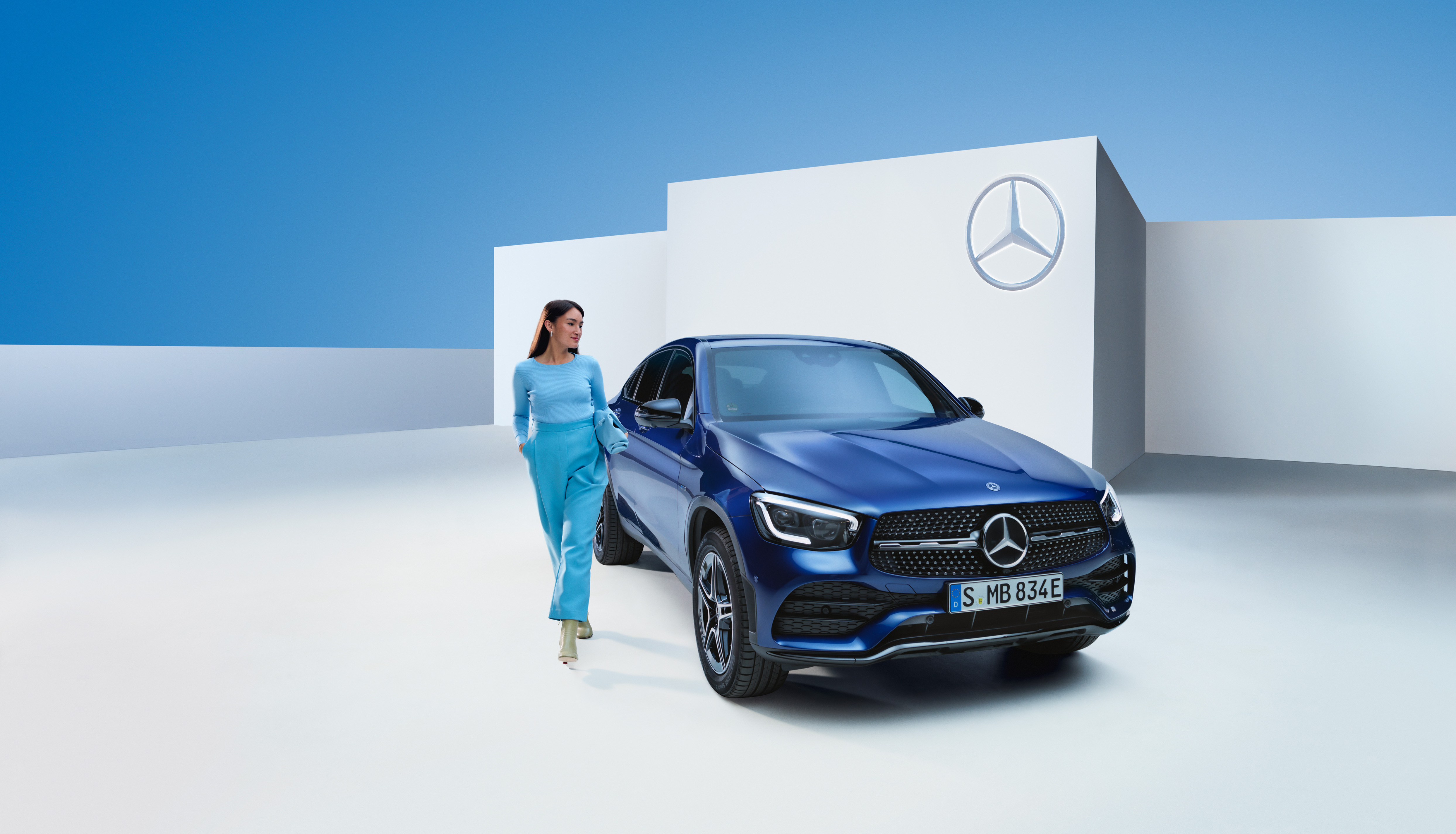 Garancia | Mercedes-Benz Egy nő sétál a Mercedes-Benz autója mellett.