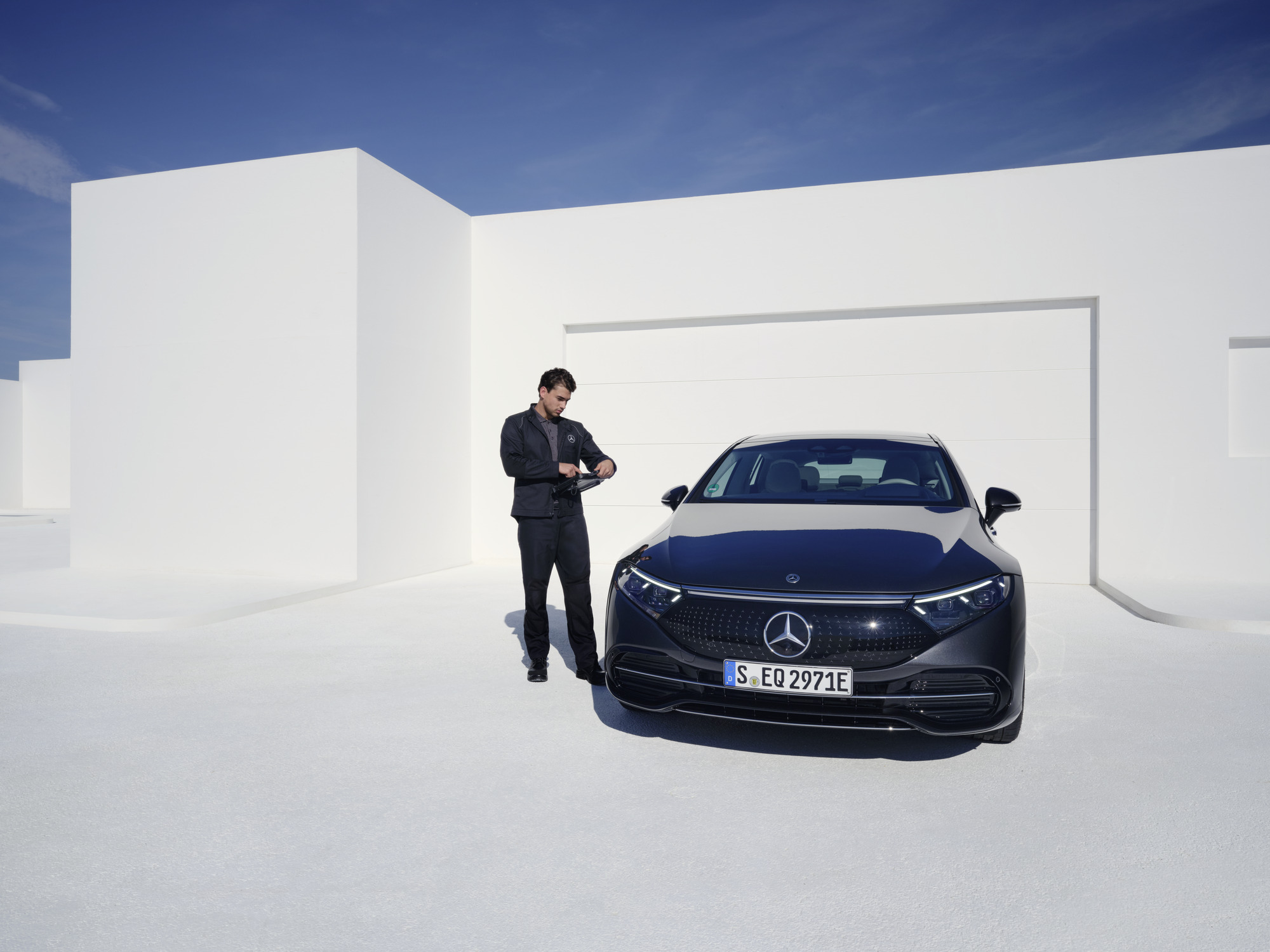 Elektromos járművek karbantartása | Mercedes-Benz Egy Mercedes-Benz szerelő átvizsgál egy Mercedes-Benzt.