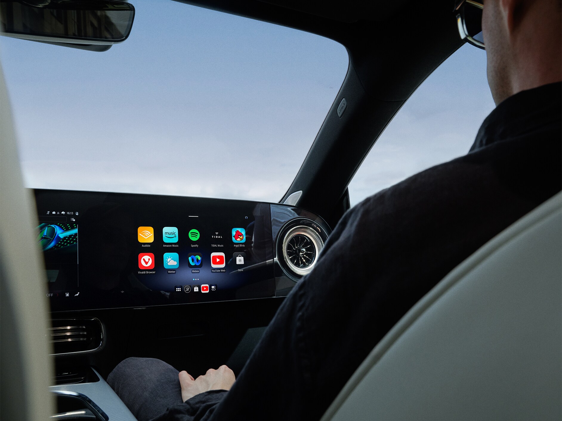 Belső nézet egy Mercedes-Benz személygépkocsi MBUX multimédia-rendszerrel felszerelt vezetőfülkéjéről.