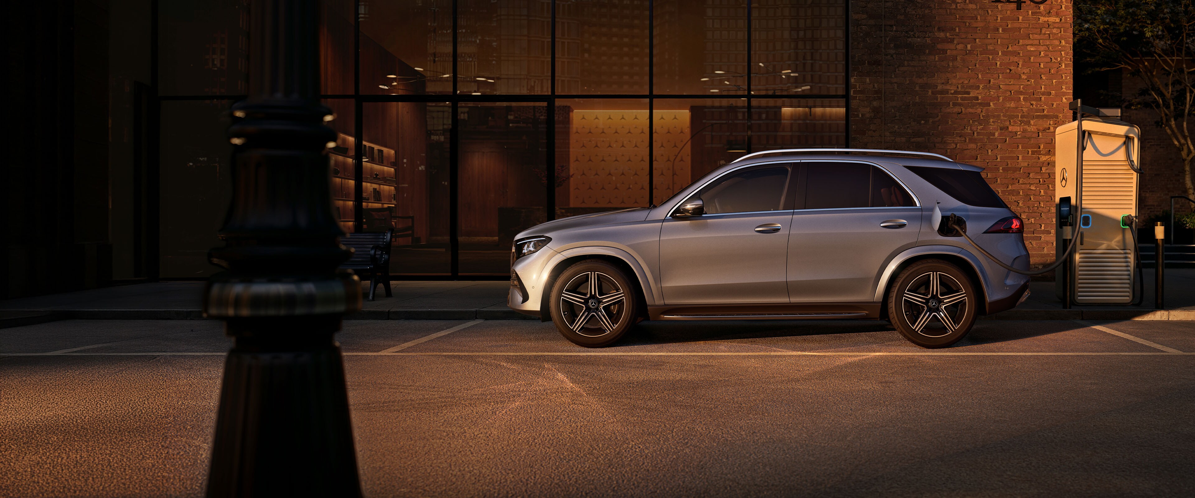 A Mercedes-Benz GLE SUV oldalnézetben egy nagy ház előtt.