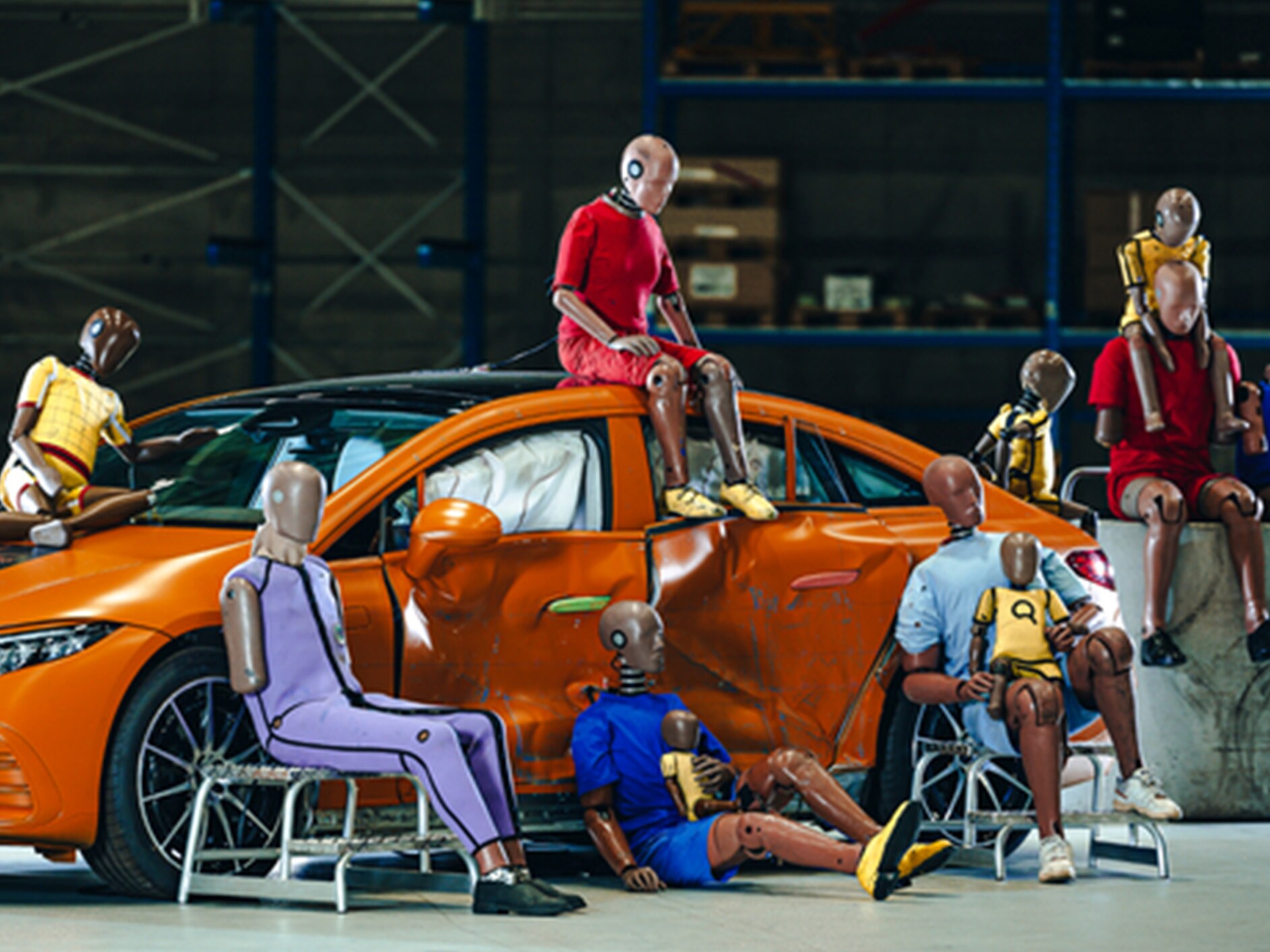 Több törésteszt-bábu ül egy Mercedes-Benz autóban és körülötte.