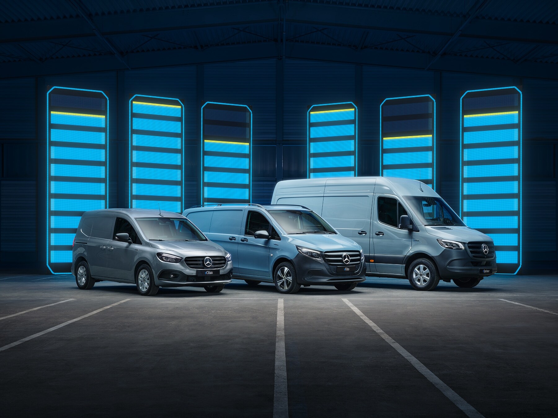A Mercedes-Benz elektromos kishaszongépjármű modelljeit egy futurisztikus raktárban mutatták be, megvilágított töltőállomásokkal