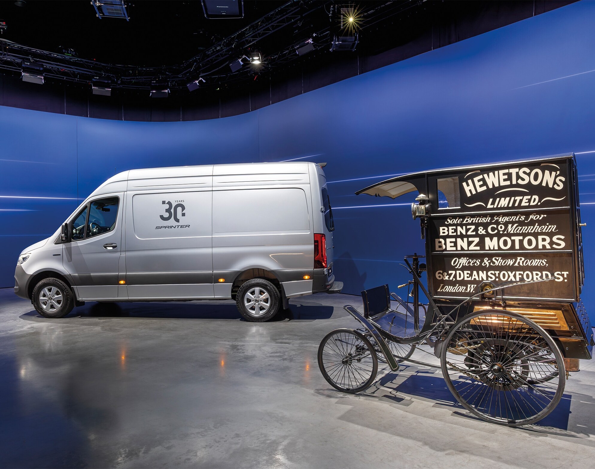 Mercedes-Benz Sprinter kishaszongépjármű és egy történelmi Benz áruszállító egy modern bemutatóteremben