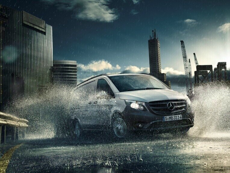 Városi környezetben vízen áthaladó Mercedes-Benz Vito zárt áruszállító.
