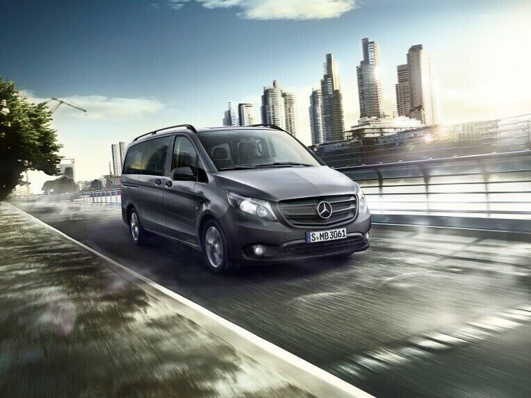 Mercedes-Benz Vito Tourer városi úton, felhőkarcolókkal a háttérben.