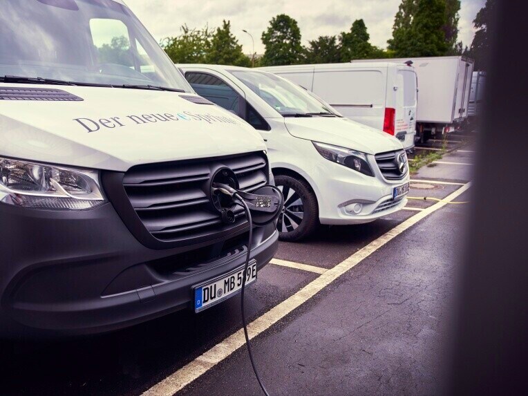 A teljesen elektromos Mercedes-Benz eSprinter egy töltőállomáson. A háttérben további elektromos kishaszongépjárművek állnak.