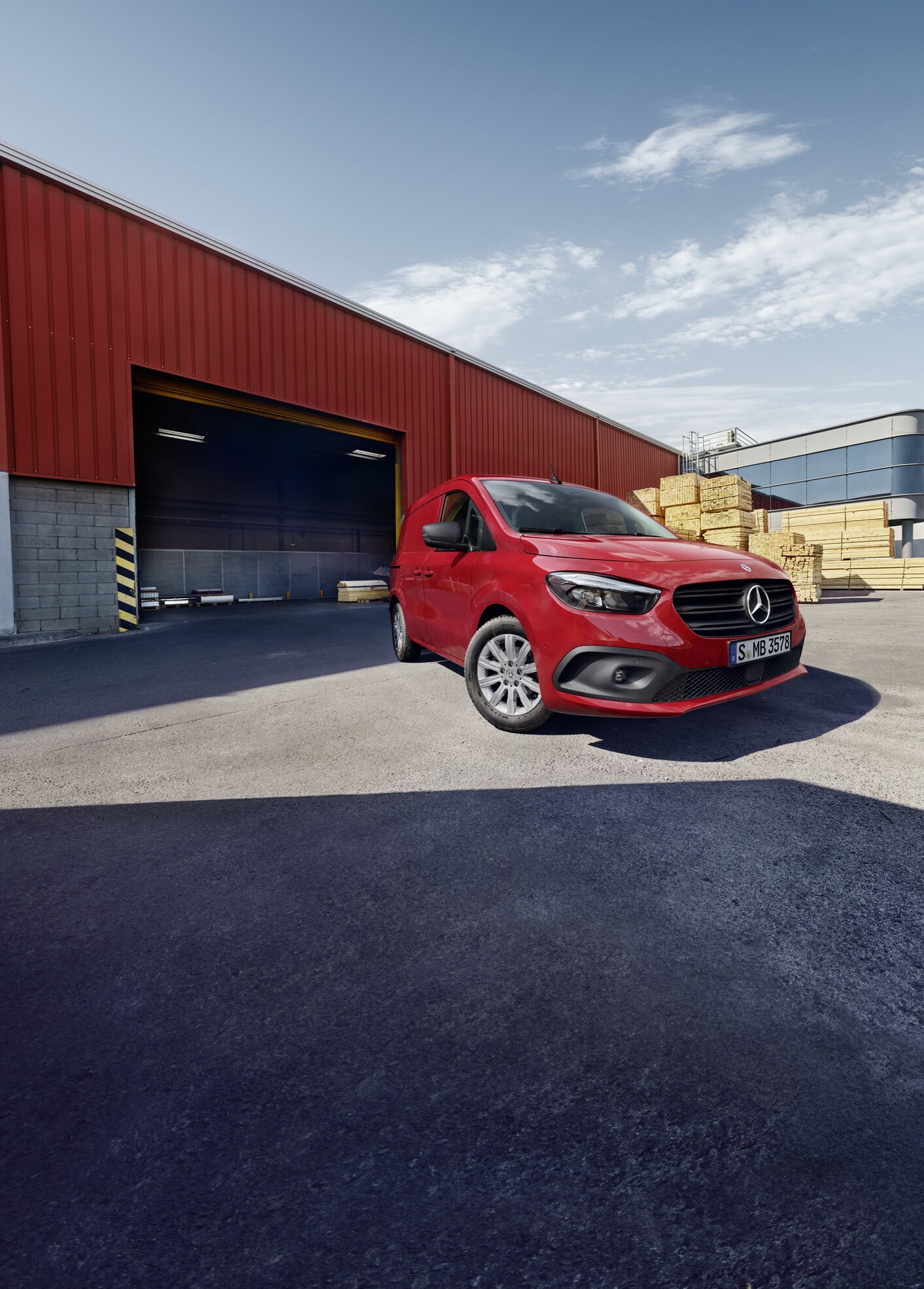 Egy Mercedes-Benz eCitan zárt áruszállító áll egy logisztikai telephelyen.