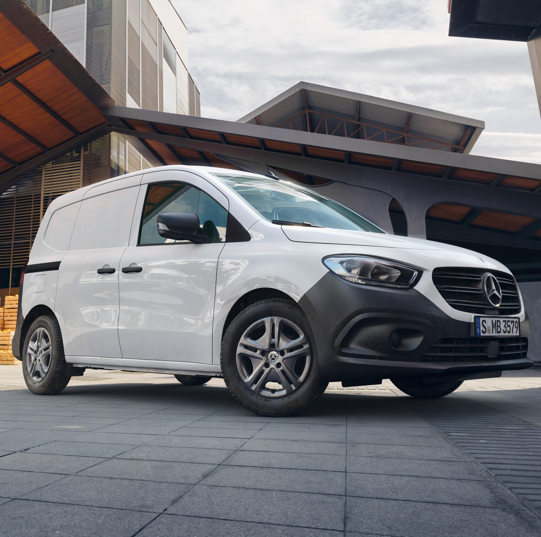 A Mercedes-Benz Citan zárt áruszállító a városban egy házfal előtt.