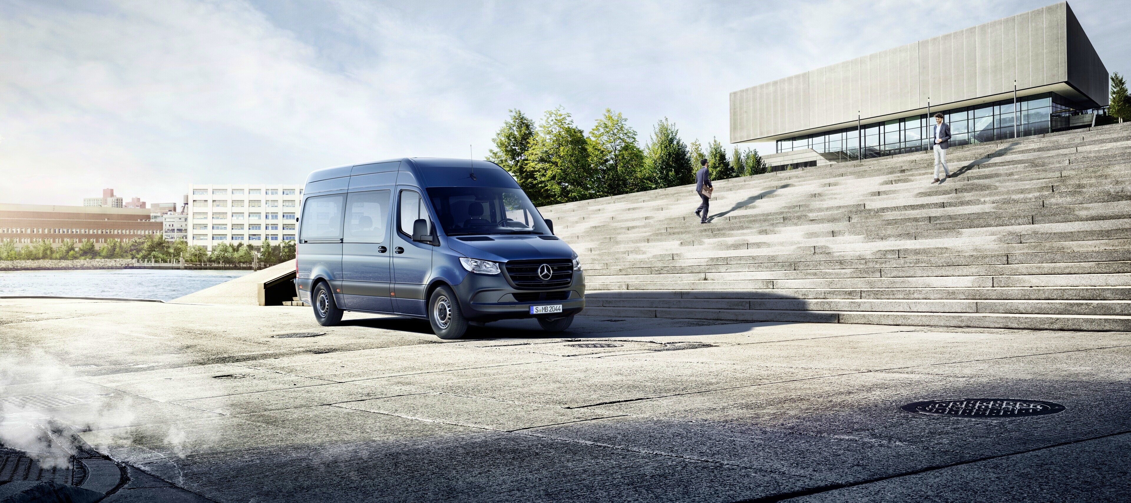 Járműösszehasonlítás | Sprinter Tourer | Mercedes-Benz A Mercedes-Benz Sprinter Tourer egy épület előtt.