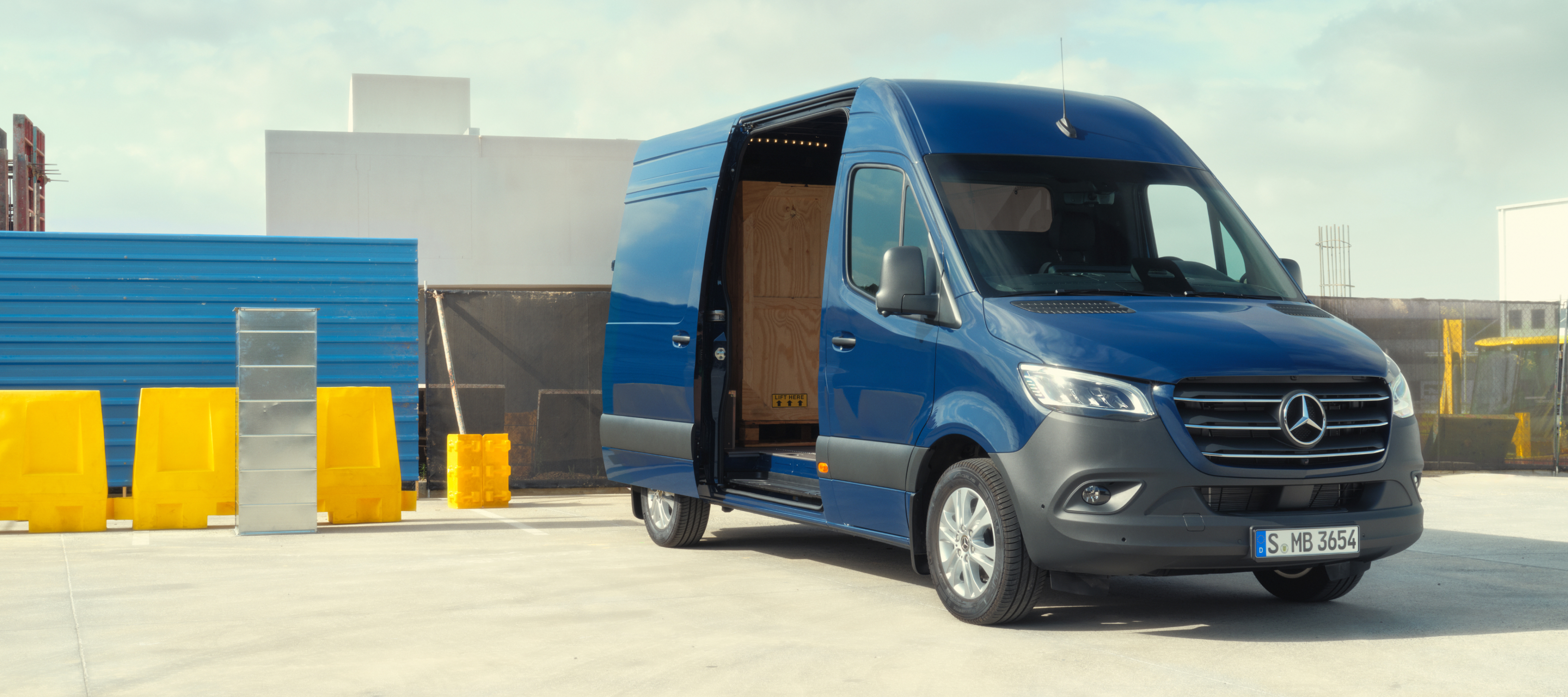 Járműösszehasonlítás | Sprinter zárt áruszállító | Mercedes-Benz A Mercedes-Benz Sprinter zárt áruszállító építőanyagok előtt.