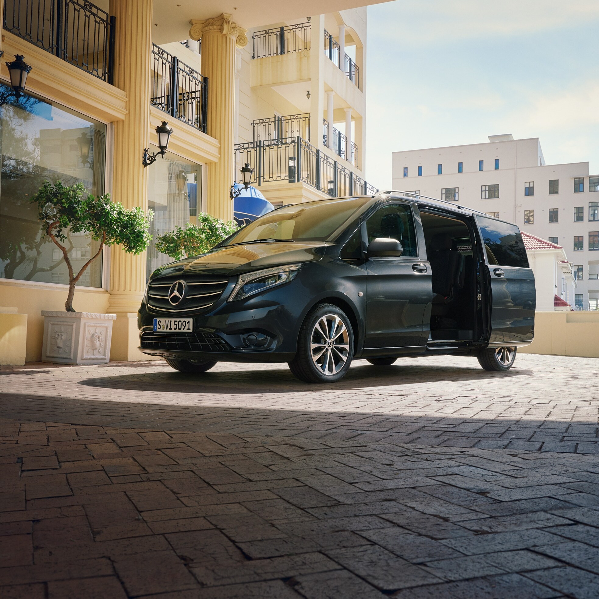 Egy Mercedes‑Benz Vito Tourer egy exkluzív épület bejáratánál parkol