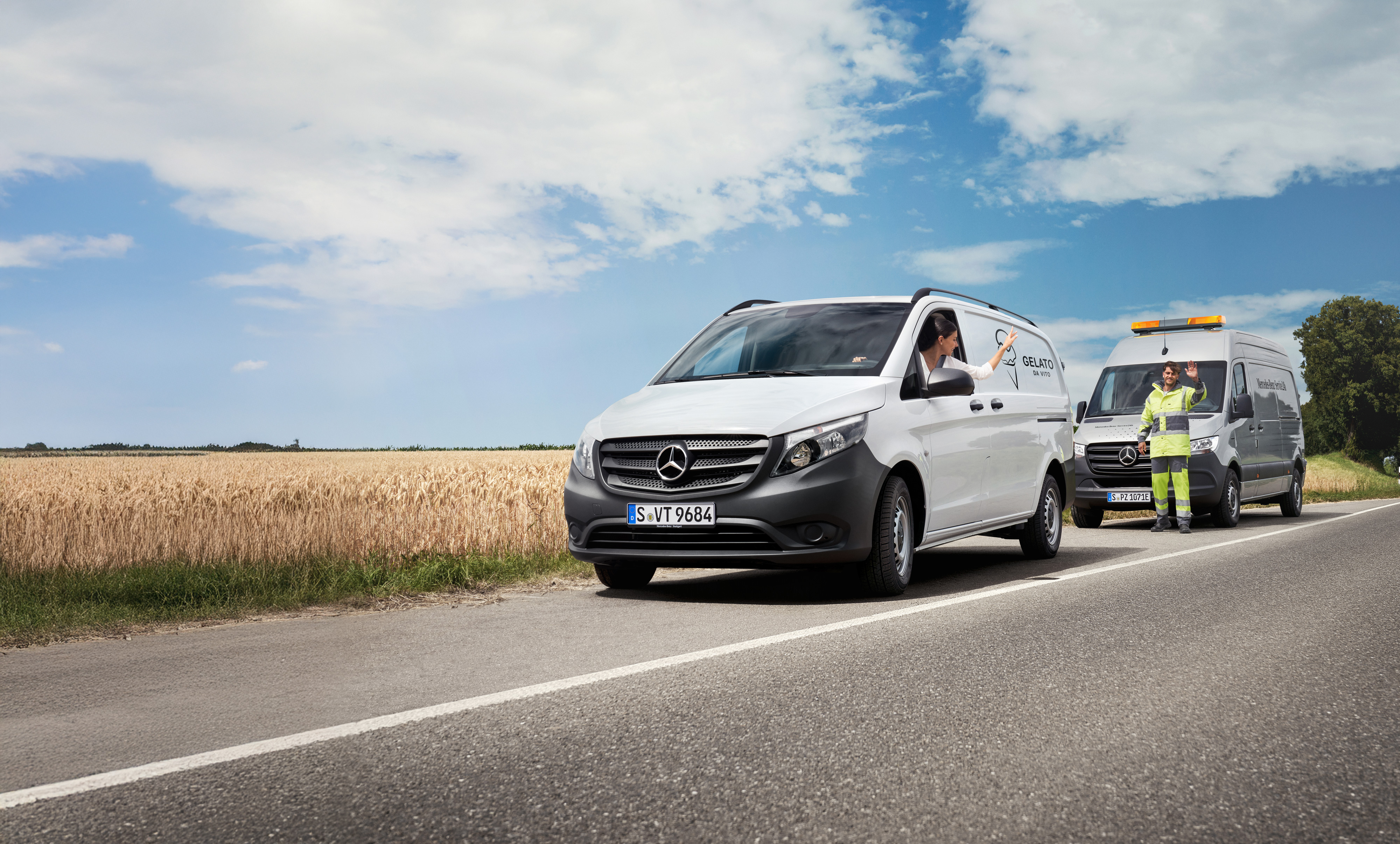 Mercedes-Benz | Komfort | MobiloVan Egy fehér Mercedes-Benz Vitóban ülő nő integet a Mercedes-Benz szerviz út szélén álló technikusának.