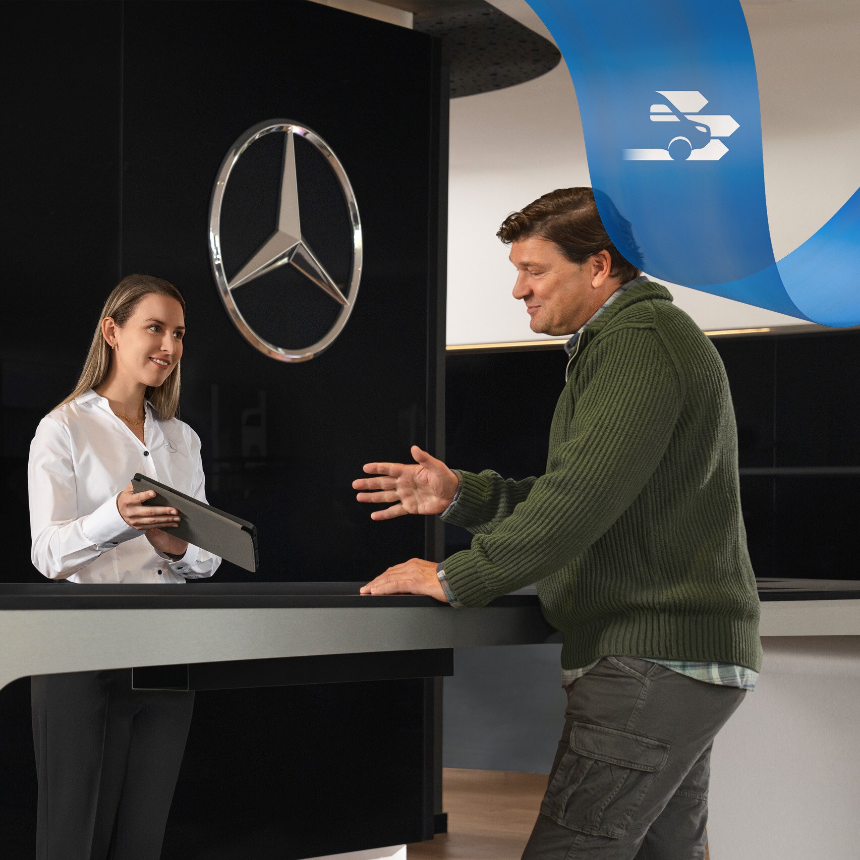 A Mercedes-Benz munkatársa a recepciónál állva nyújt segítséget egy ügyfélnek.